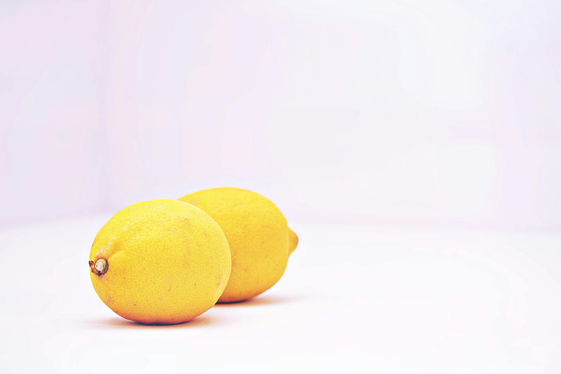 Two fresh lemons on a white background symbolizing gentle, careful sensation recovery