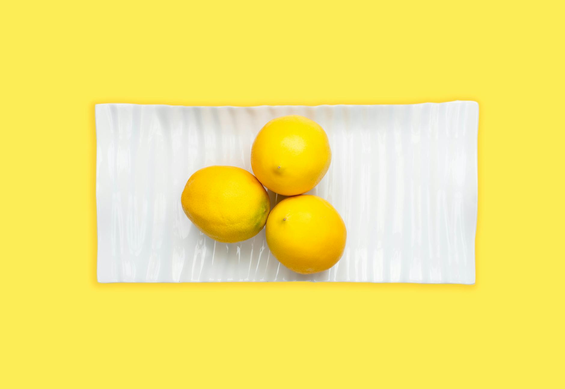 Colorful clitoral vibrators arranged on a bright yellow surface, representing diverse pleasure options for different sensitivity needs