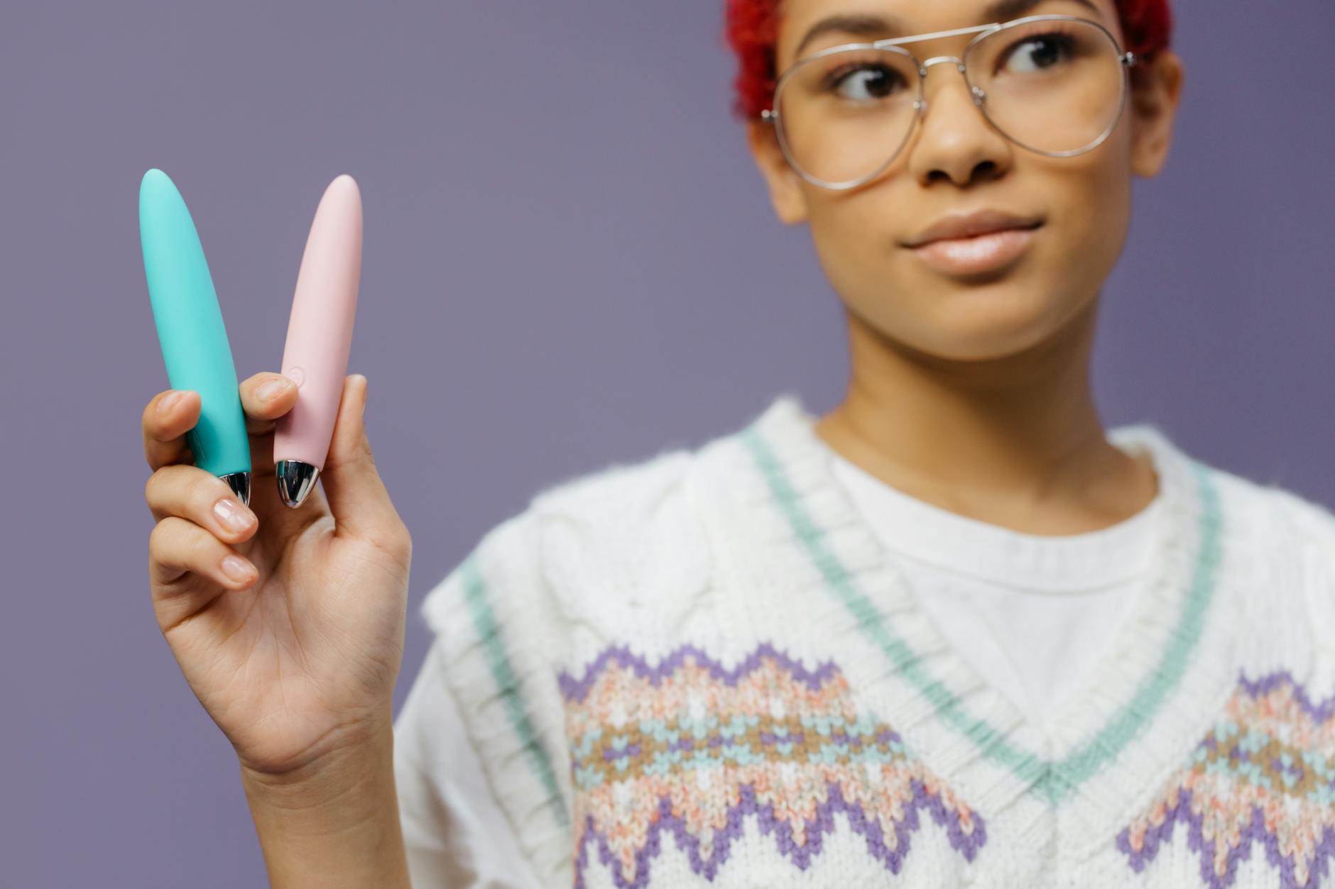 A person holding two colorful vibrators, representing options for managing pleasure during medication transitions