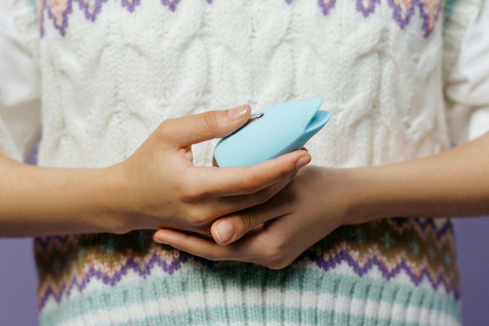 A young couple standing together indoors, holding a vibrator, symbolizing modern intimacy and partnership.