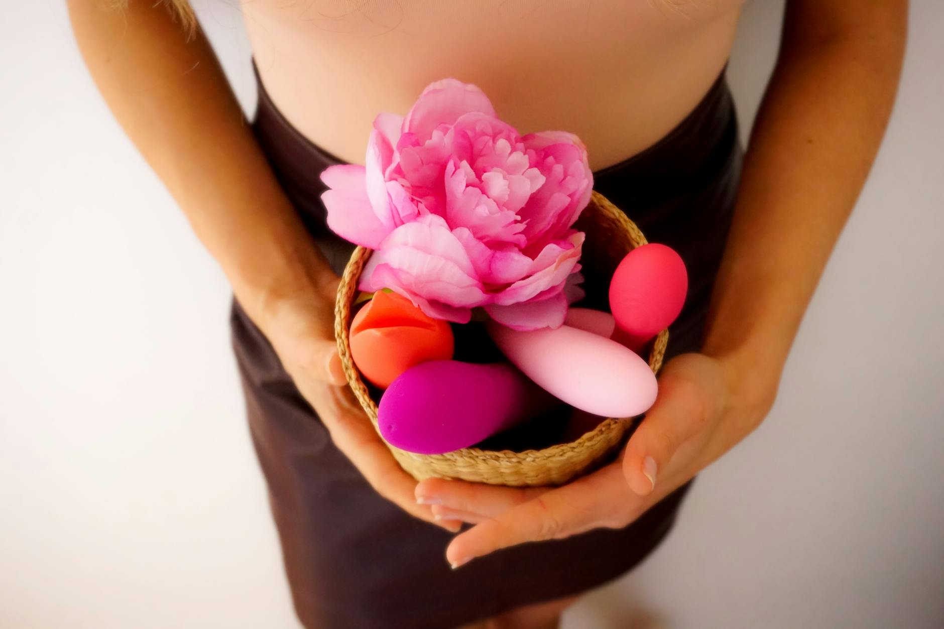 A vibrant collection of various clitoral vibrators on a black tray, featuring diverse shapes and colors.
